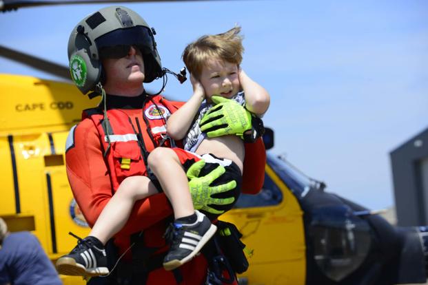Coast Guard Petty Officer 3rd Class Evan Gallant, a rescue swimmer from Air Station Miami, carries a boy away from an MH-60 Jayhawk helicopter in Beaumont, Texas, Aug. 31, 2017 (U.S. Coast Guard/Petty Officer 3rd Class Corinne Zilnicki)