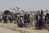 Supporters of the Taliban carry the Taliban's signature white flags