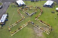 Human chain in the shape of a yellow suicide awareness ribbon