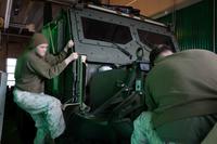 Marine hops onto a Medium Tactical Vehicle Replacement