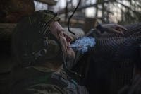 A Ukrainian serviceman from the Azov brigade, known by the call sign Chaos, smokes a cigarette