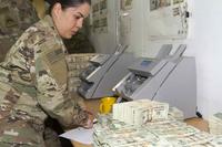 A deputy disbursing officer counts money at Camp Arifjan, Kuwait