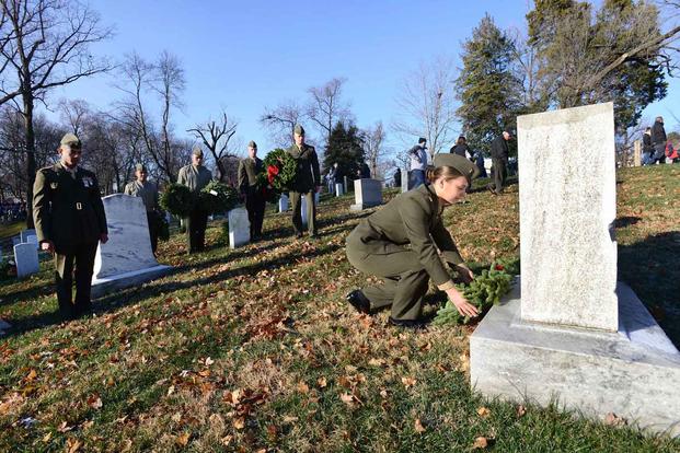 marine decorates grave in arlington cemetery