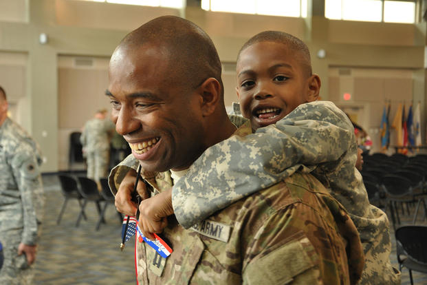 Georgia Army National Guard Capt. Chad Tyson receives a hug from son Chase during a welcome home ceremony for the Georgia National Guard’s Agribusiness Development Team III in Marietta, Georgia. (National Guard/William Carraway)