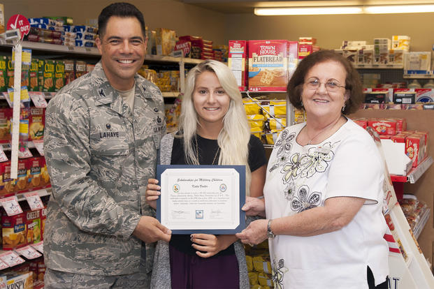 Katie Vosler, center, accepts a $2,000 college scholarship from Col. Dwayne LaHaye, left, the 71st Mission Support Group commander, and Sheila Gilbert, the director of the Vance Air Force Base Commissary, during a brief ceremony at the Commissary.  (U.S. Air Force/James Bolinger)