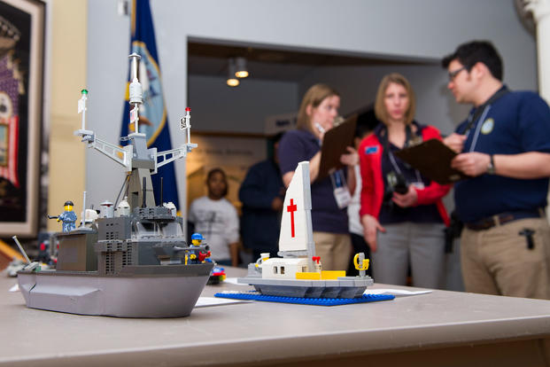 Judges examine an entry during the Brick-by-Brick Lego Shipbuilding Competition at the Hampton Roads Naval Museum. (Defense Department)