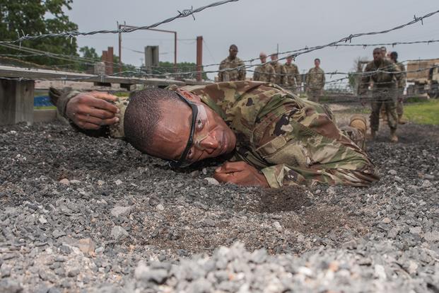 Pfc. Michael Williams, Company A, 2nd Battalion, 10th Infantry Regiment, low crawls under a barbed-wire obstacle at the confidence course as part of a six-week Basic Combat Training cycle for prior-service Soldiers. Williams, who served in the U.S. Navy from 2008 to 2014, is one of 32 prior-service Soldiers conducting training with Co. A. (Stephen Standifird/U.S. Army)