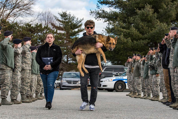 Members of the 436th Security Forces Squadron render a final salute to retired Military Working Dog Rico. (U.S. Air Force/Roland Balik)