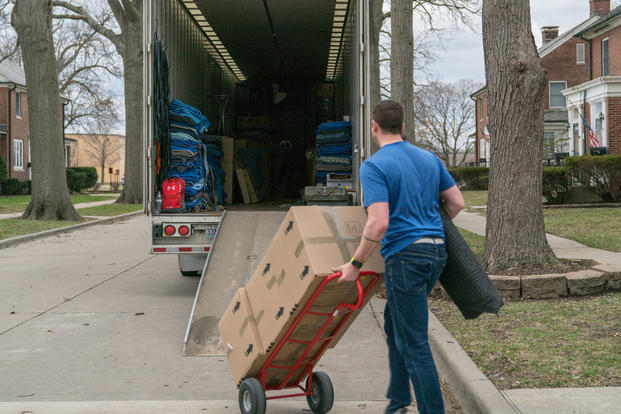 A moving contractor loads a moving truck with a service member's household goods.