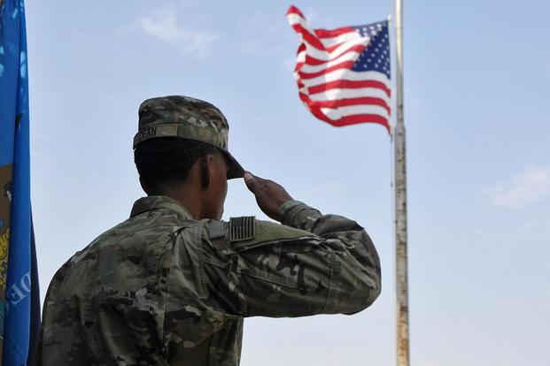 A soldier salutes the U.S. flag during the singing of the National Anthem on Sept. 11, 2017, at Camp Arifjan, Kuwait. (U.S. Army photo by Sgt. Kimberly Browne)
