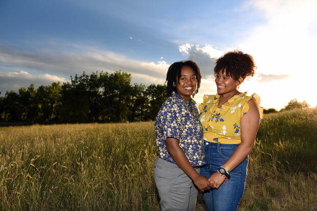U.S. Air Force Tech. Sgt. Nykita Stoudemire, left, an Air Reserve Personnel Center reserve assignments technician, joins hands with her wife, Marissa, in Aurora, Colorado, June 21, 2018. (U.S. Air Force photo/Jazmin Smith)