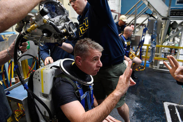 A Navy diver gives the okay sign following his dive using the Office of Naval Research TechSolutions-sponsored MK29 Mixed Gas Rebreather system developed at the Naval Surface Warfare Center Panama City Division, Apr. 4, 2018. (U.S. Navy photo/John F. Williams)