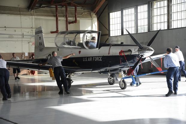 Maintenance personnel roll a T-6 Texan II into a hangar July 9, 2014, at Joint Base San Antonio-Randolph. (U.S. Air Force/A1C Stormy D. Archer)
