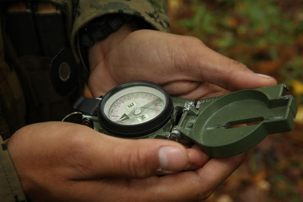 A Marine reads a compass during a land navigation training event in 2013. Several officers could lose their commissions after being accused of cheating on a land nav event while attending The Basic School. (Lance Cpl. Justin Rodriguez/Marine Corps)
