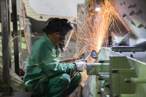 Department of Defense civilian employee Sithon Lag, welder, uses an angle grinder to debur metal on a Light Armored Vehicle during the rebuild process at the production plant aboard Marine Corps Logistics Base Barstow, California (U.S. Marine Corps photo by Jack J. Adamyk)