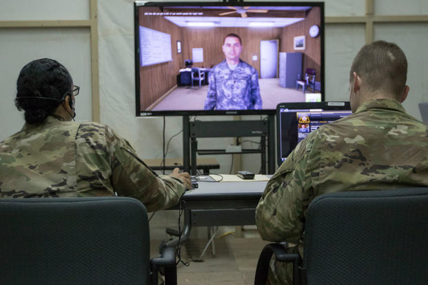 U.S. Army Master Sgt. Breyda Pereyra, left, the noncommissioned officer in charge of U.S. Army Central's G37 office, and U.S. Army Capt. Jordan Smith, the outgoing officer in charge of the U.S. Army Central Readiness Training Center, speak with a virtual soldier avatar in an Intelligence and Electronic Warfare Tactical Proficiency Trainer program designed to simulate a conversation with a soldier having suicidal thoughts, Camp Buehring, Kuwait, Sept. 12, 2018. (U.S. Army photo/Adam Parent)