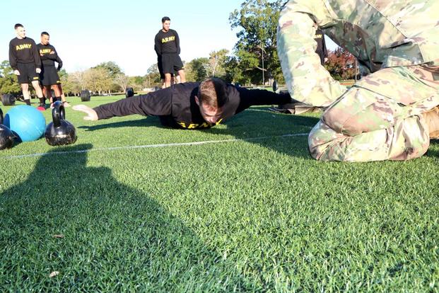 Sgt. 1st Class Brandon Estes, a member of the Army Combat Fitness mobile training team at Fort Eustis, demonstrates another alternative for the hand release pushup. (extends arms out to the sides and brings them back in between each pushup). (Military.com/Matthew Cox)