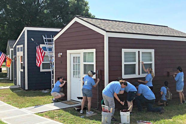 Volunteers help with the finishing touches on some of the tiny homes in the Veterans Community Project village.