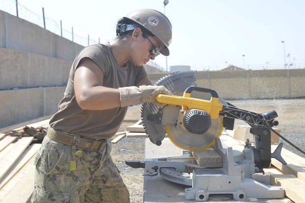 Construction electrician constructionman Stephanie N. Bugaski, from Naval Mobile Construction Battalion 133, deployed with the Combined Joint Task Force – Horn of Africa, cuts wood for new bus stops onboard Camp Lemonnier.