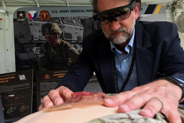 Geoffrey Miller, a research scientist at the Army's Medical Research and Materiel Command, shows how medics may one day us a heads-up display that can connect them to a surgeon in a hospital for help when treating personnel on the battlefield. (Matthew Cox/Military.com)