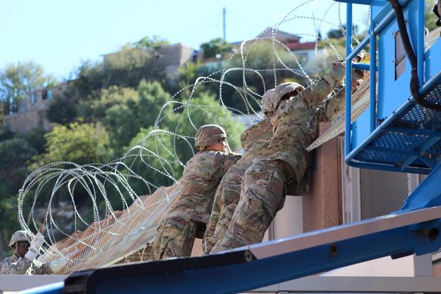 Engineer Soldiers from the 62nd Engineer Battalion, Fort Hood, Texas, add concertina wire to the top of the Arizona-Mexico border wall, Nov. 7, 2018. (U.S. Army/2nd Lt. Corey Maisch)