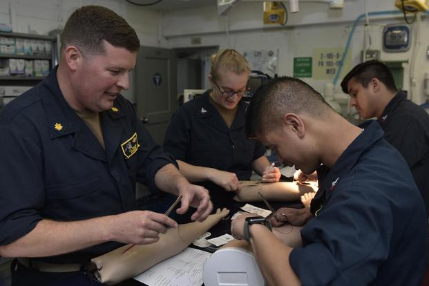 Lt. Cmdr. James Wallace, surgeon for the aircraft carrier USS Nimitz (CVN 68), teaches a group of Hospital Corpsman how to suture in the ship's medical department. (U.S. Navy/Mass Communication Specialist 3rd Class Christopher R. Jahnke)
