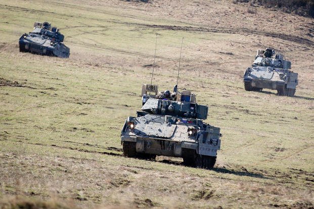 A group of M2 Bradley fighting vehicles move to secure an area during a Robotic Complex Breach Concept demonstration at Grafenwoehr Training Area, Germany, on April 6, 2018.  The Robotic Complex Breach Concept employs the use of Robotic and Autonomous Systems (RAS) for intelligence, suppression, obscuration, and reduction missions. (U.S. Army photo by Spc. Hubert D. Delany III/22nd Mobile Public Affairs Detachment)