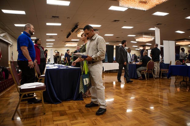 Veterans and service members speak with business representatives about job opportunities at the Recruit Military Job Fair at San Diego, July 11, 2019. (U.S. Marine Corps photo/Jake McClung)