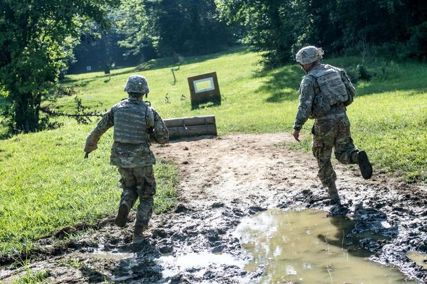 A sergeant from the 4th Infantry Division running near cadets as they negotiate the new buddy-team live fire course at ROTC Advanced Camp at Fort Knox, Kentucky. (U.S. Army/Spc. Dana Clarke)