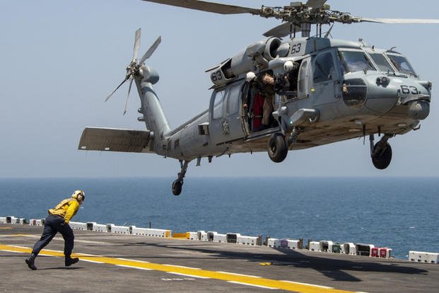 Aviation Boatswains Mate (Handling) 2nd Class Bradley Peterson, assigned to amphibious assault ship USS Boxer (LHD 4) runs to a bean-bag dropped on the flight deck during an exercise to communicate with USS Boxer from an MH-60S Sea Hawk assigned to Helicopter Sea Combat Squadron (HSC) 21, Aug. 4, 2019. (U.S. Navy photo)