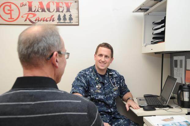 Lt. Cmdr. Brett Lacey, gastroenterologist, Naval Hospital Pensacola, speaks to a patient about getting screened for Hepatitis C during a routine exam Feb. 1 at Naval Hospital Pensacola. (Jason Bortz/U.S. Navy)