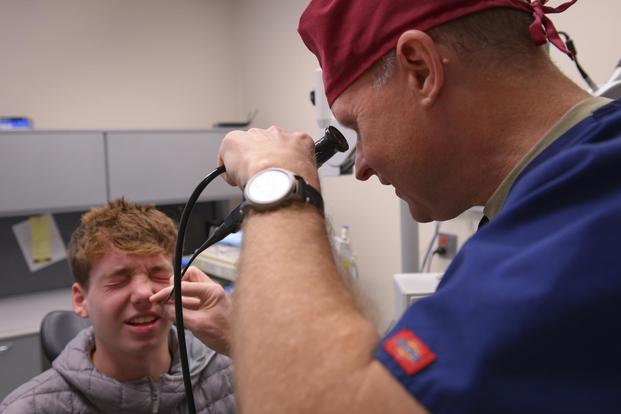 Lt. Col. Chester Barton, 374th Ear Nose and Throat Clinic otolaryngologist, examines a Yokosuka Naval Base high school student for nasal damage at Yokota Air Base, Japan, Feb. 16, 2017. (U.S. Air Force/Senior Airman Elizabeth Baker)