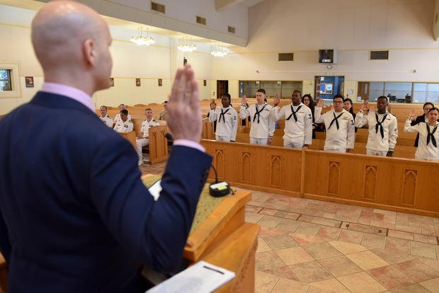 Steven Pilling, field office director for U.S. Citizenship and Immigration Services, Seoul, Korea administers the Oath of Allegiance to 17 naturalization candidates from 11 different countries during a naturalization ceremony at the main chapel onboard Commander, Fleet Activities Yokosuka (CFAY), Aug. 22, 2019. (U.S. Navy photo/Tyler R. Fraser)