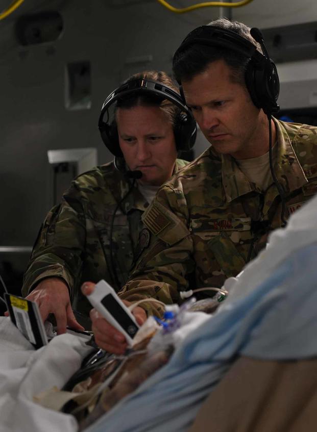 Lt. Col. Valerie Sams, 59th Medical Wing trauma surgeon, and Lt. Col. Scott King, 86th Aeromedical Evacuation Squadron critical care air transport team physician, perform an ultrasound on a critically wounded service member during a flight from Bagram Airfield, Afghanistan, to San Antonio on Aug. 18, 2019. (U.S. Air Force photo by Airman 1st Class Ryan Mancuso)