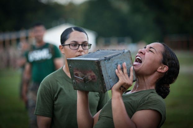 An officer candidate conducts the ammo can lift portion while another officer candidate counts the repetitions during the combat fitness test (CFT) at Marine Corps Officer Candidates School aboard Marine Corps Base Quantico, Virginia, July 16, 2019. (U.S. Marine Corps/Phuchung Nguyen)