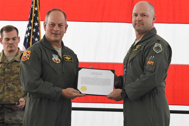 Retired Brig. Gen. Jim Mackey presents the Distinguished Flying Cross with Valor citation to Lt. Col. Anthony Roe, a flight commander with the 303d Fighter Squadron, during a ceremony at Whiteman Air Force Base, Mo., Nov. 2, 2019. (U.S. Air Force/Airman 1st Class Alex Chase)