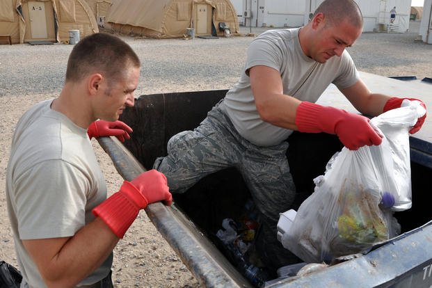 Airmen collect trash.
