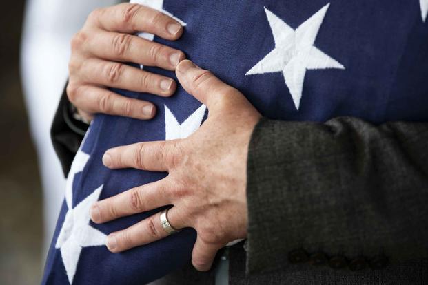 Receiving a folded flag during a funeral service. (Staff Sgt. Jamarius Fortson/U.S. Army photo)
