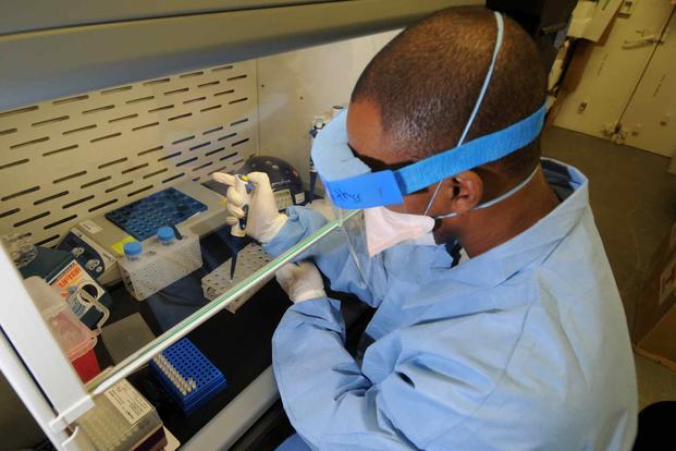 U.S. Air Force Tech. Sgt. Vernon Smith extracts ribonucleic acid from a nasopharyngeal swab sample.