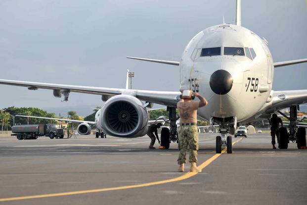 Sailors place chocks under a P-8A Poseidon on Joint Base Pearl Harbor-Hickam.