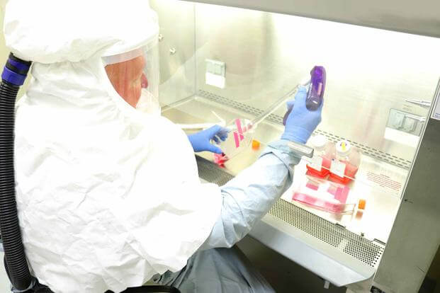 A microbiologist harvests coronavirus at a lab at Fort Detrick.