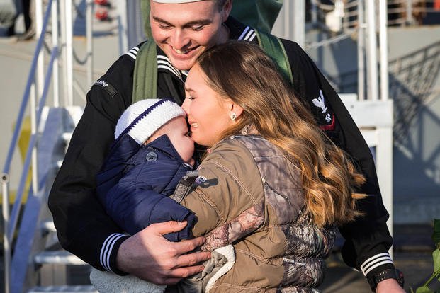 couple with baby embracing after deployment