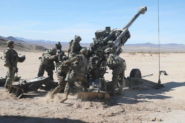 U.S. Army soldiers load a round into an M777 Howitzer.