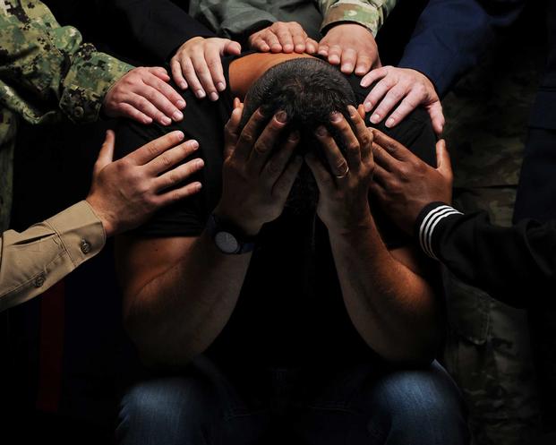 Distraught servicemember being assisted by others