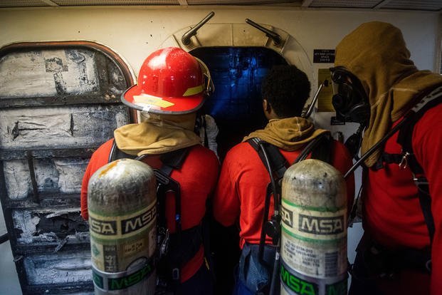 Coast Guardsmen onboard Coast Guard Cutter Waesche survey damage