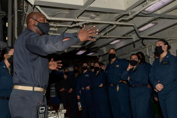 Chief Operations Specialist Travone Steele speaks to his division aboard the USS Theodore Roosevelt.