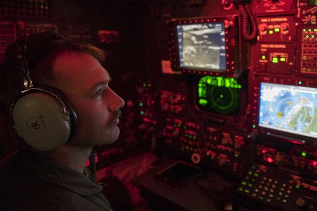 A U.S. Air Force weapons systems officer monitors aircraft screens.