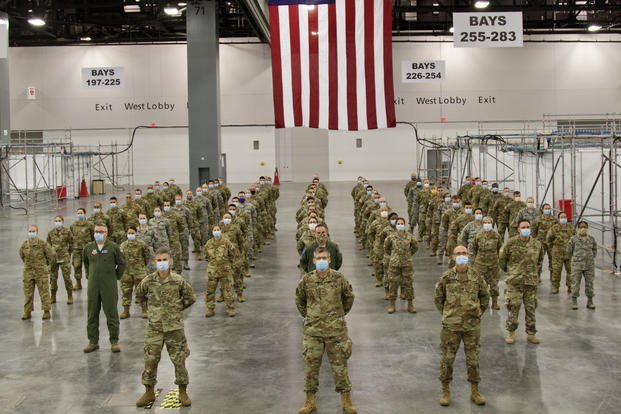 Medial professionals in the Army and Air National Guard pose for a group photo at an alternate care facility Miami Beach Convention Center. (Leia Tascarini/Army)