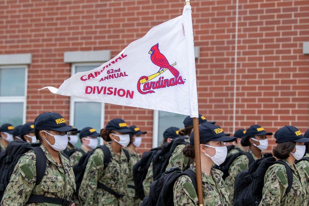 recruit marches in formation carrying the St. Louis Cardinals flag