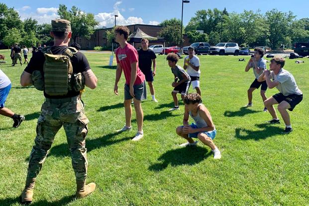 A U.S. Army Recruiter motivates young football players.